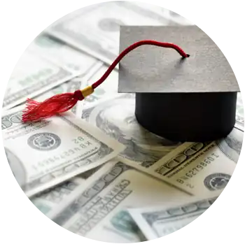 A tiny paper graduation cap and tassel are on top of some cash.