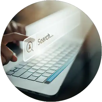 A person is pointing to a search bar displaying on their laptop.